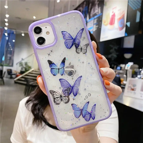 A woman holding a phone case with butterflies on it