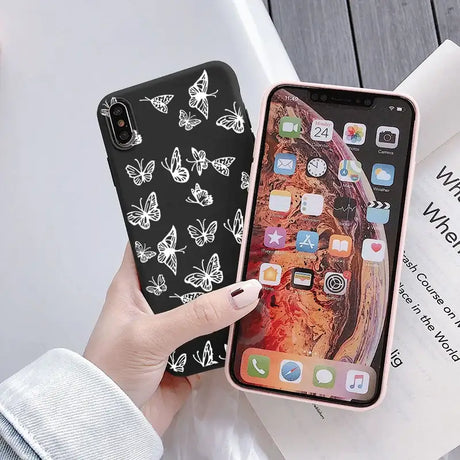 A woman holding a phone case with butterflies on it