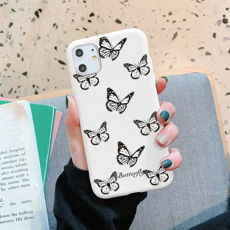 A woman holding a phone case with butterflies on it