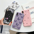 A woman holding a phone case with butterflies on it