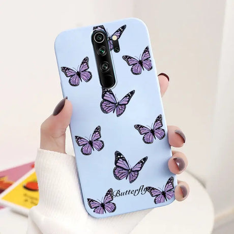 A woman holding a phone case with butterflies on it