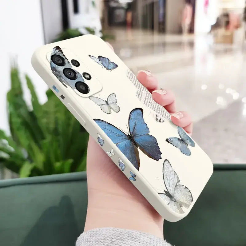 a woman holding a phone case with butterflies on it