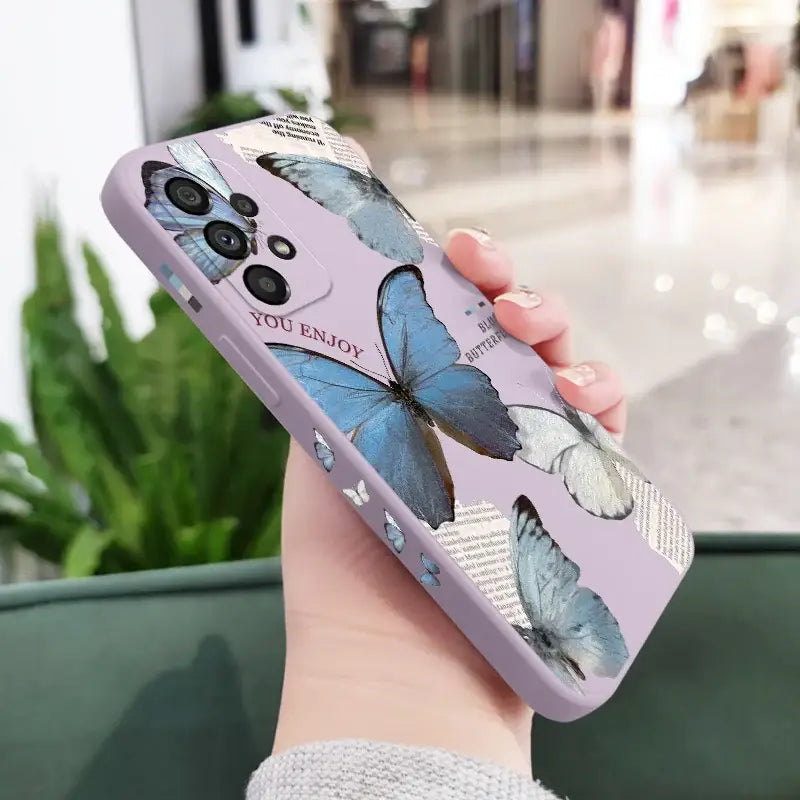 a woman holding a phone case with butterflies on it