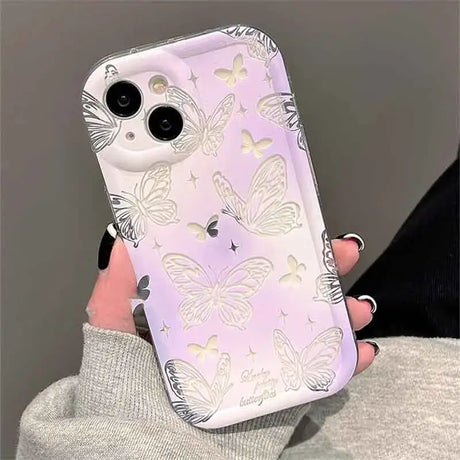 A woman holding a phone case with butterflies on it