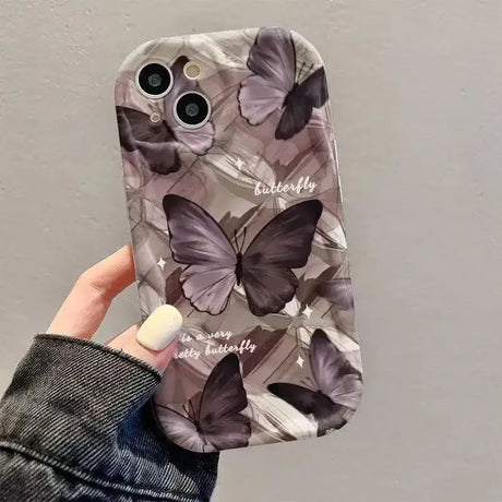 A woman holding a phone case with a butterfly pattern