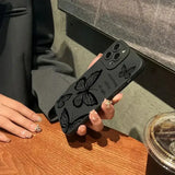 A woman holding a phone case with a butterfly design