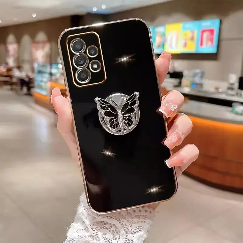 a woman holding up a phone case with a butterfly on it