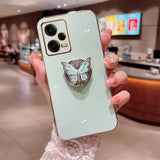 a woman holding a phone case with a butterfly on it