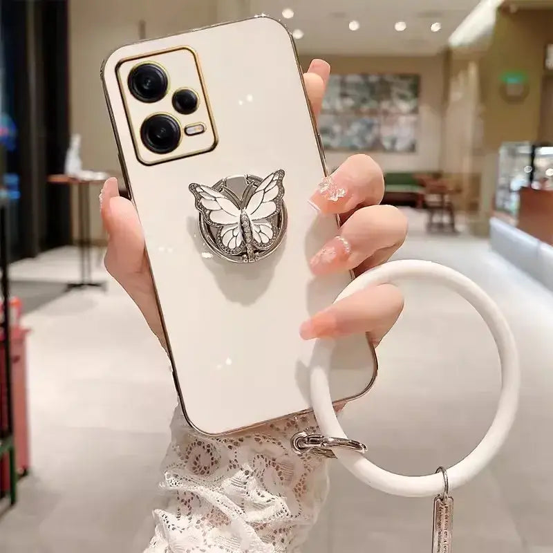 A woman holding a phone case with a butterfly on it