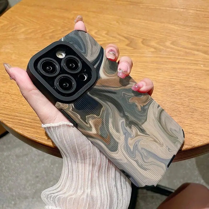 a woman holding a phone case with a camouflage pattern