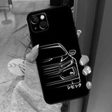 a woman holding up a phone case with a car logo