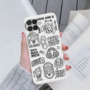 a woman holding a phone case with cartoon drawings on it