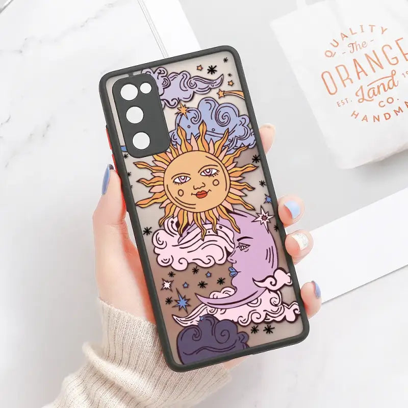 a woman holding a phone case with a cartoon sun and clouds