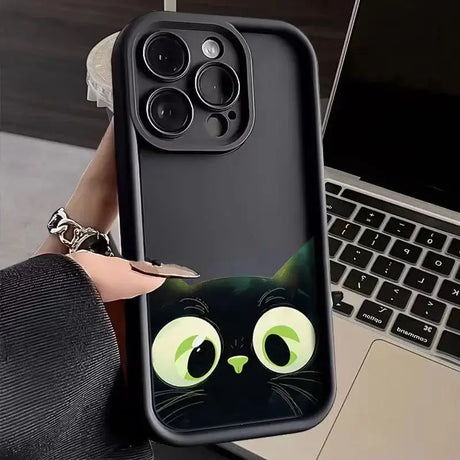 A woman holding a phone case with a cat face on it