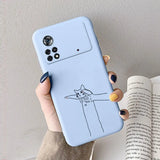 A woman holding a phone case with a cat drawing on it