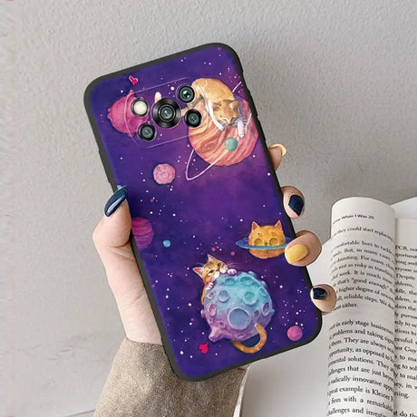 a woman holding a phone case with a cat and planets