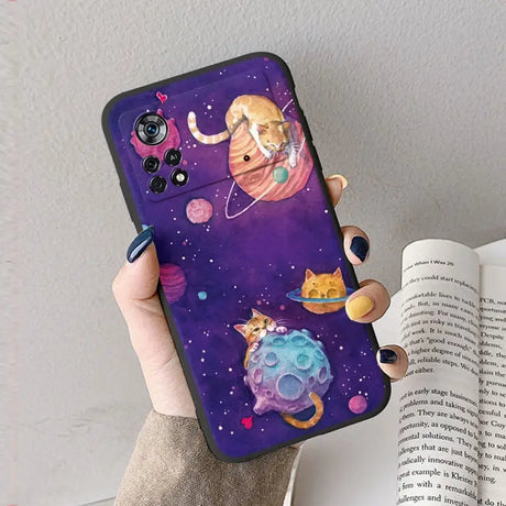 A woman holding a phone case with a cat and planets