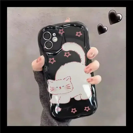 A woman holding a phone case with a cat on it