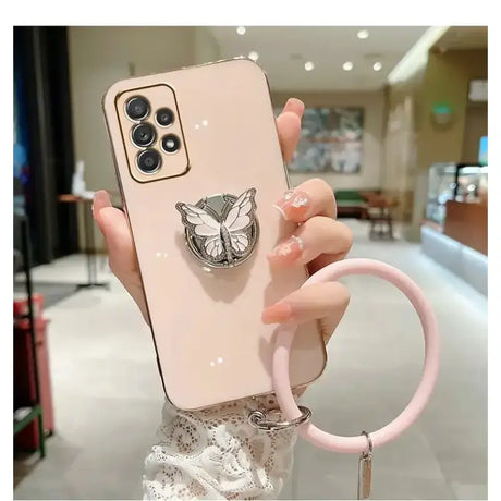 A woman holding a phone case with a cat head on it