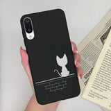 a woman holding a phone case with a cat on it