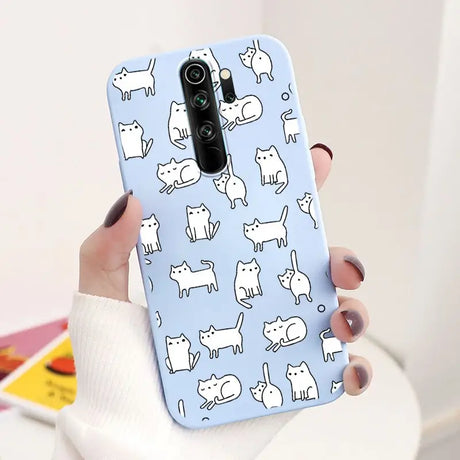 A woman holding a phone case with cats on it