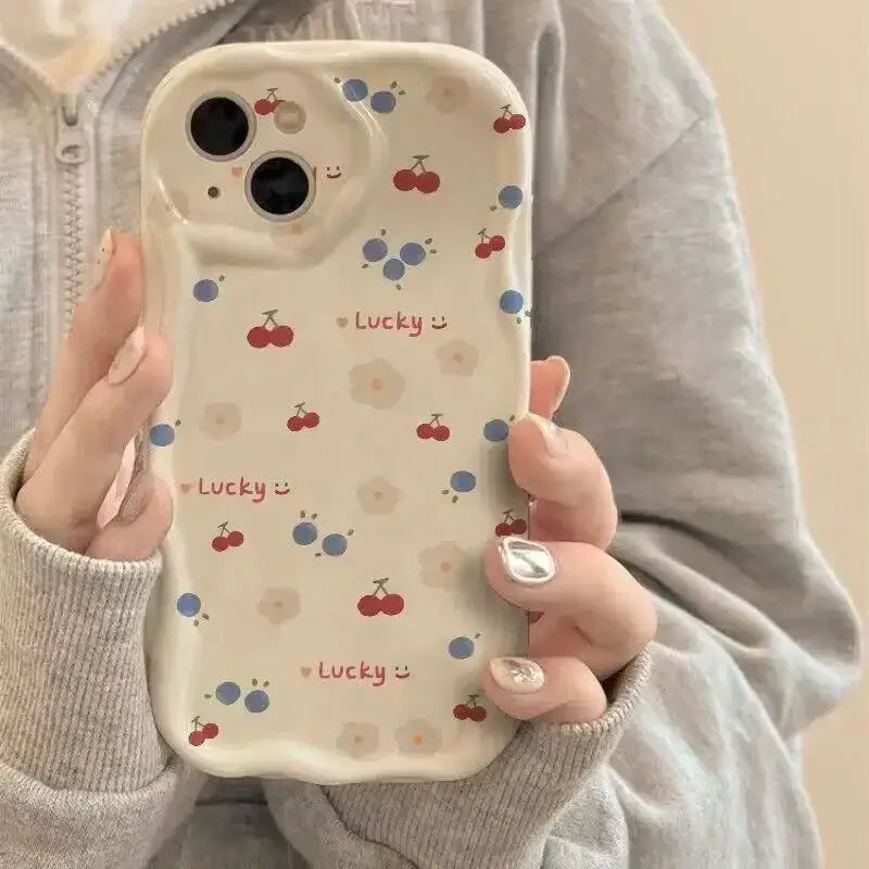 a woman holding a phone case with cherry design