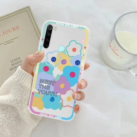 a woman holding a phone case with a colorful pattern