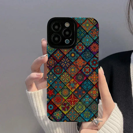 a woman holding up a phone case with colorful geometric designs