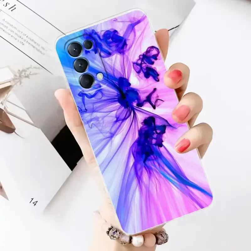 a woman holding a phone case with a colorful liquid painting on it