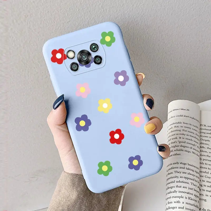a woman holding a phone case with colorful flowers on it