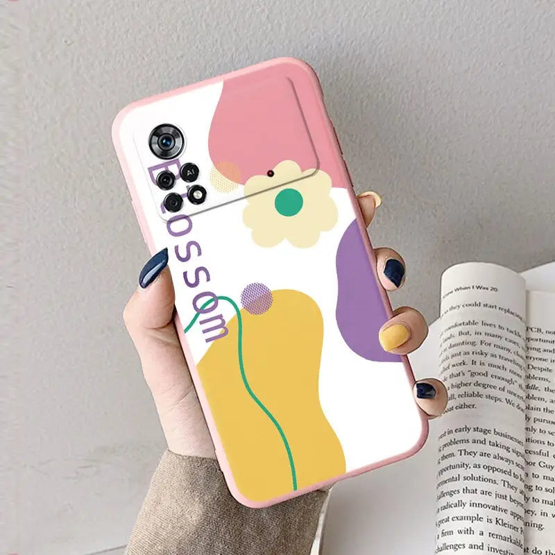 a woman holding a phone case with a colorful flower design
