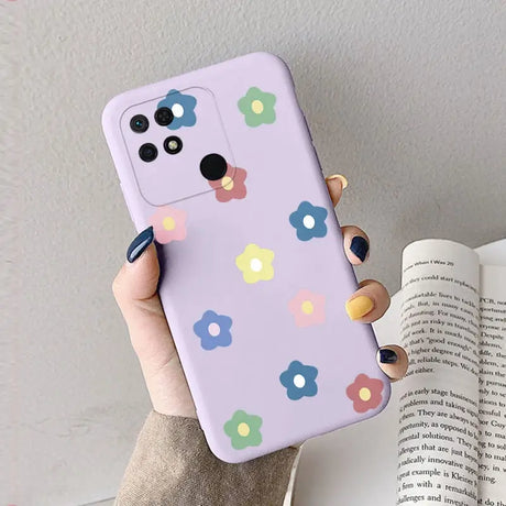 a woman holding a phone case with colorful flowers on it