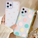 a woman holding a phone case with a colorful polka dot pattern