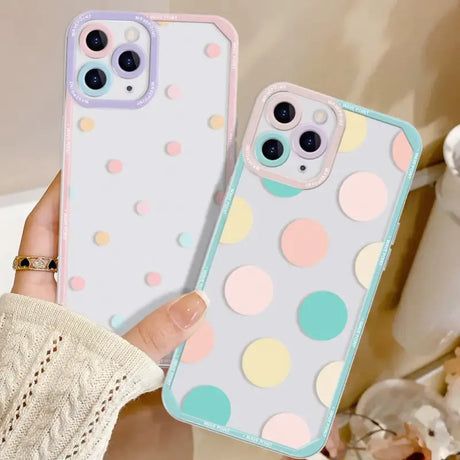 A woman holding a phone case with a colorful polka dot pattern