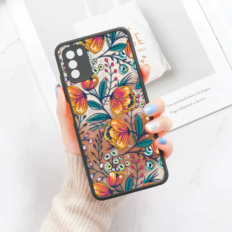 a woman holding a phone case with colorful flowers