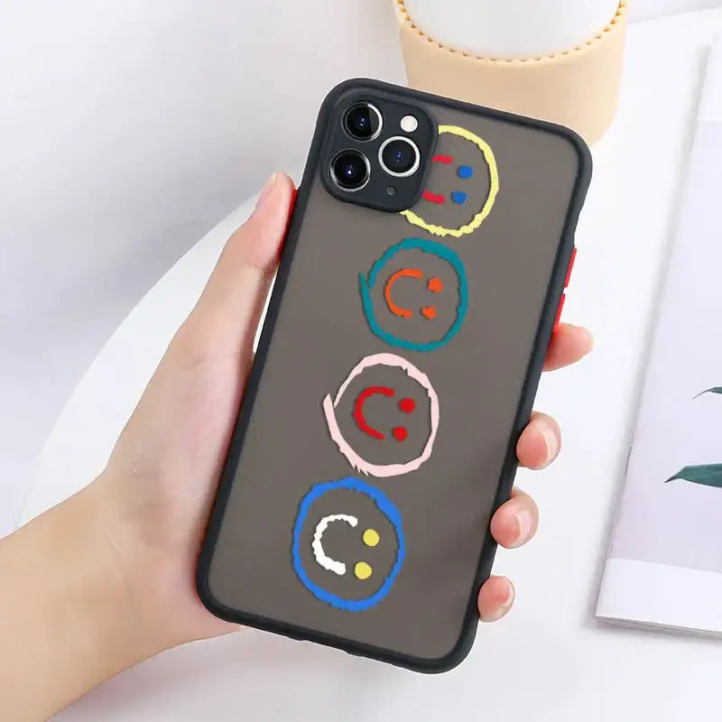 a woman holding a phone case with a colorful circle design