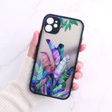 A woman holding a phone case with a colorful tropical print