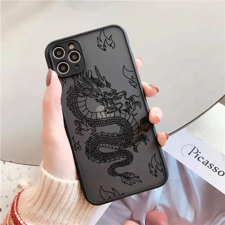 A woman holding a phone case with a dragon on it