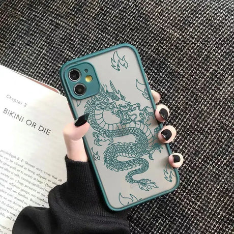 A woman holding a phone case with a dragon design on it