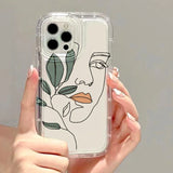 a woman holding a phone case with a face drawn on it