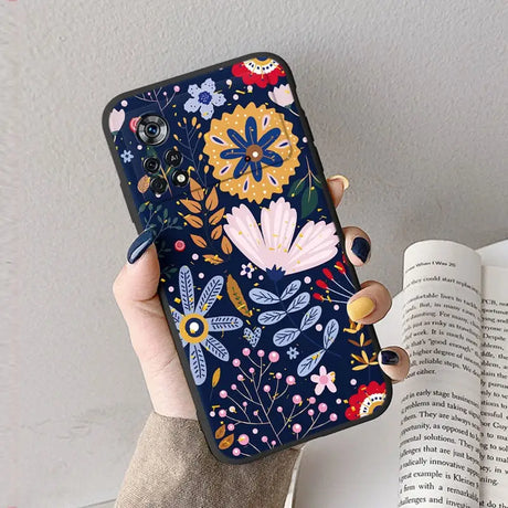 A woman holding a phone case with a floral pattern