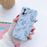a woman holding a phone case with a floral pattern