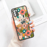 A woman holding a phone case with a floral pattern