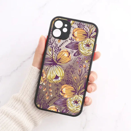 A woman holding a phone case with a floral pattern