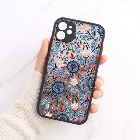 A woman holding a phone case with a floral pattern