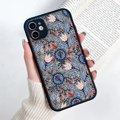 A woman holding a phone case with a floral pattern