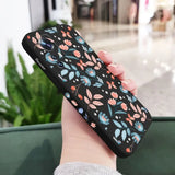 a woman holding a phone case with a floral pattern