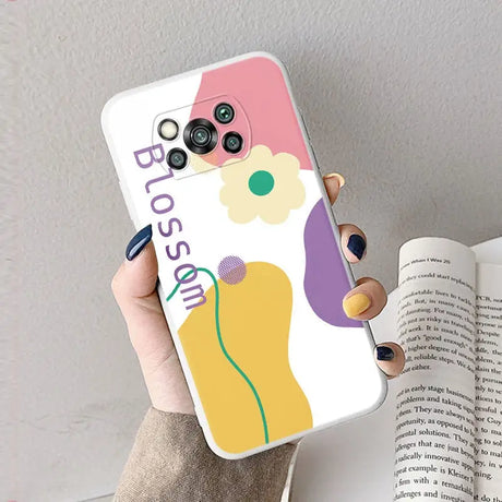 a woman holding a phone case with a flower on it