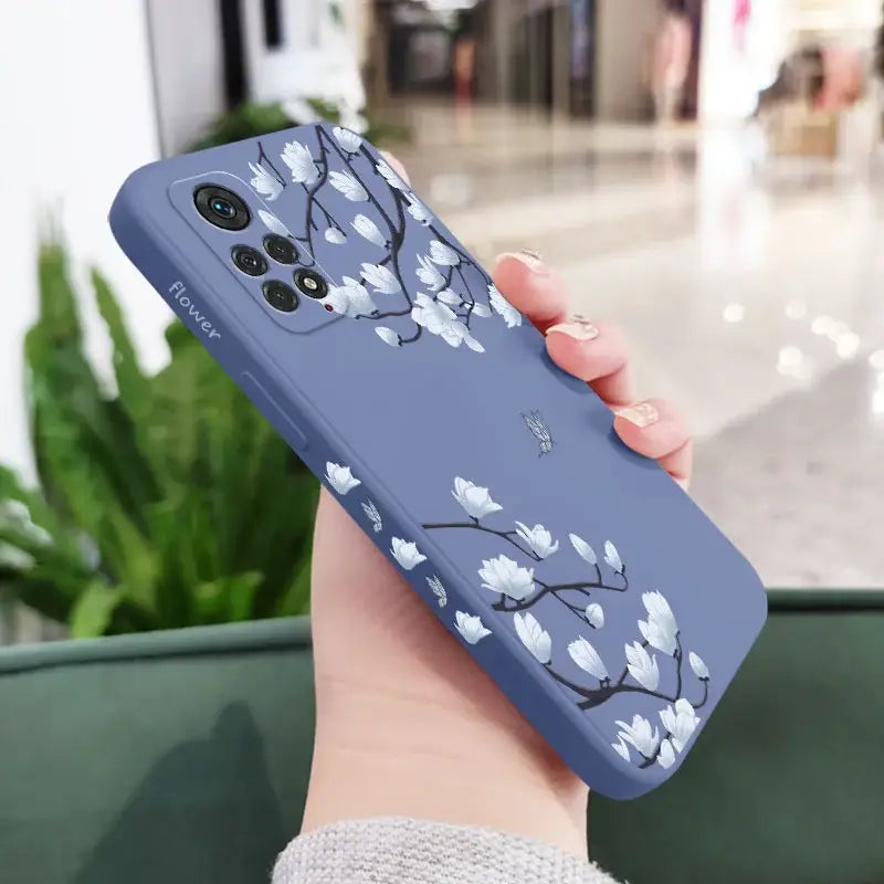 A woman holding a phone case with a flower pattern