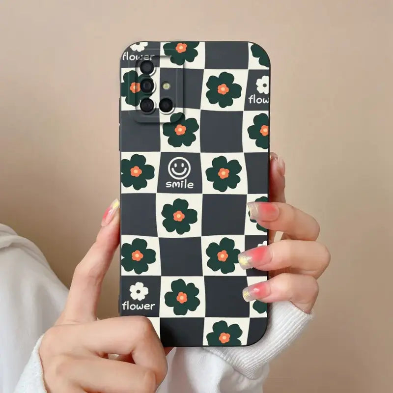 a woman holding up a phone case with a flower pattern